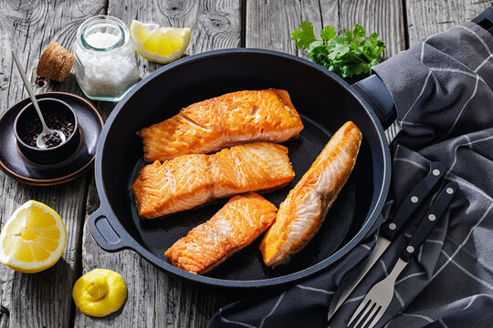Pan-seared salmon fillets on a skillet, close-up