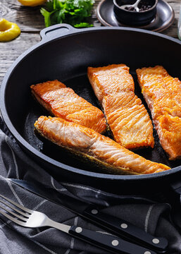 Pan-seared salmon fillets on a skillet, close-up