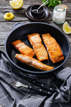 Pan-seared salmon fillets on a skillet, close-up