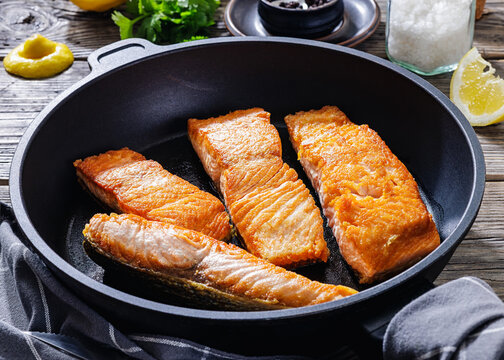 Pan-seared salmon fillets on a skillet, close-up