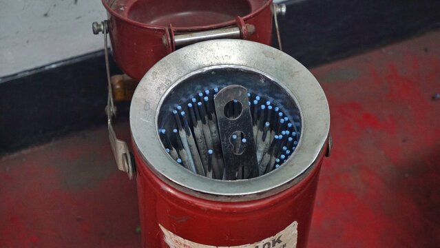 Close-up of industrial metal cleaning machine with abrasive materials