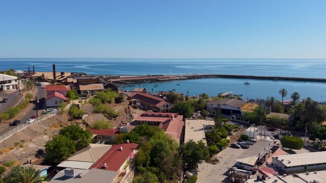 Enjoy stunning aerial views of Santa Rosalia, Baja California Sur, showcasing its coast and unique buildings on a clear day.