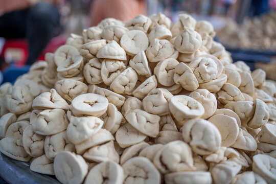 Sun-dried black gram dumplings, known as daler bori, displayed at a rural Bangladeshi village market. A traditional homemade ingredient used in everyday Bengali cooking