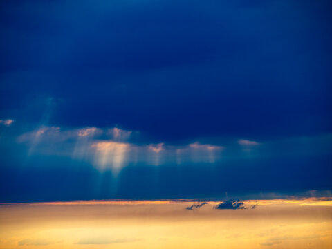 Sonnenstrahlen durchdringen den Wolkenhimmel bei Sonnenuntergang
