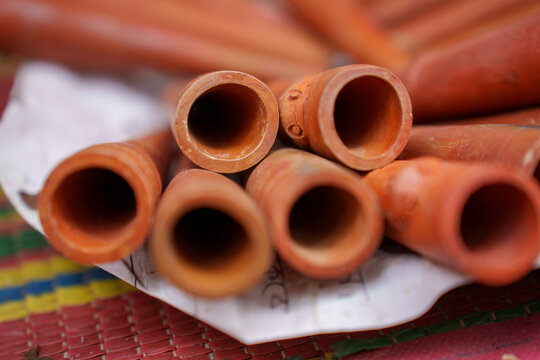 Handcrafted clay chillums called Kalki, sold by street vendors across Bangladesh. Traditional terracotta smoking pipes shaped by local artisans, reflecting centuries of folk craft heritage.