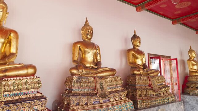 Pull Out movement of a row of golden Buddha statues seated in meditation at Wat Pho Temple in Bangkok, evoking a serene and spiritual atmosphere, reflecting rich cultural and religious heritage.