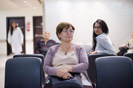 Middle Eastern patient waiting in eye hospital clinic with doctors and family in a modern Egyptian facility