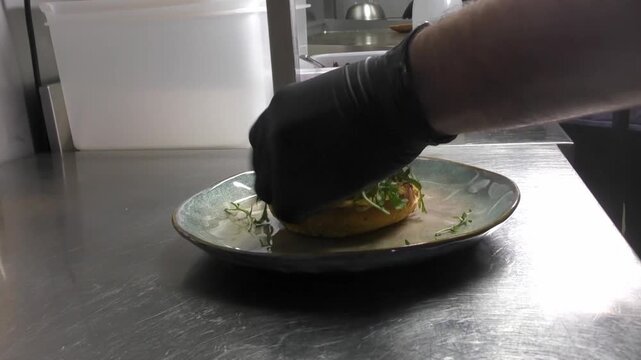 Preparazione di un panino hamburger su piastra. Panino hamburger grigliato con pancetta, cipolla glassata, formaggio e uova