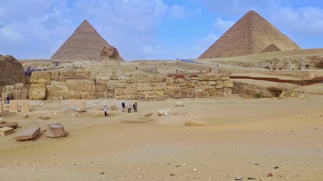 Panoramic view of the great pyramids and sphinx of giza, Cairo. Tourists walking around the ancient egyptian necropolis