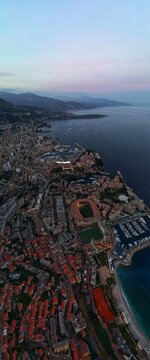 Aerial view of Monaco City with the Stade Louis II and the harbor under a twilight sky Monaco, Monaco.