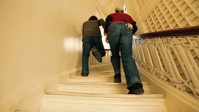 Young People Walking Up Spiral Stairs
