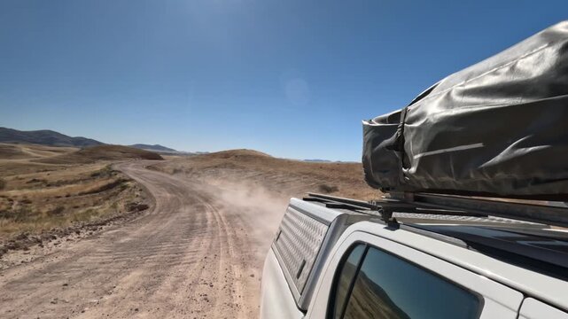 View of the rear of the white car, dusty road, a lot of dust, driving a car, Africa