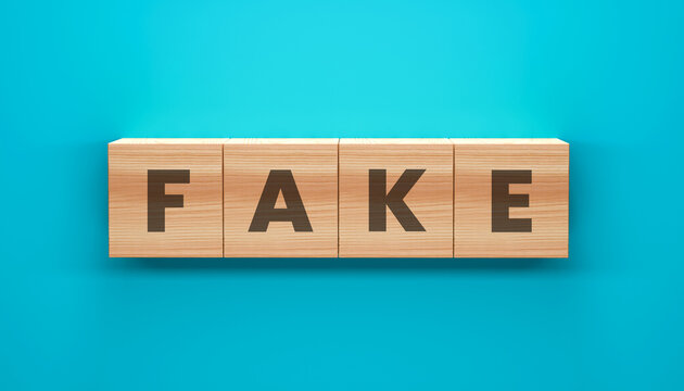 Fake Blocks: Four wooden blocks spelling out the word FAKE, offering a conceptual representation of deception or falsehood, set against a calm blue backdrop. 