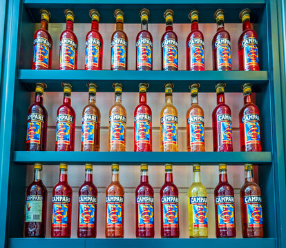 Munich, Germany - July 19: Shelves hold various Campari bottles in different colors. Bright labels stand out under warm afternoon light in a store setting in Munich on July 19, 2018