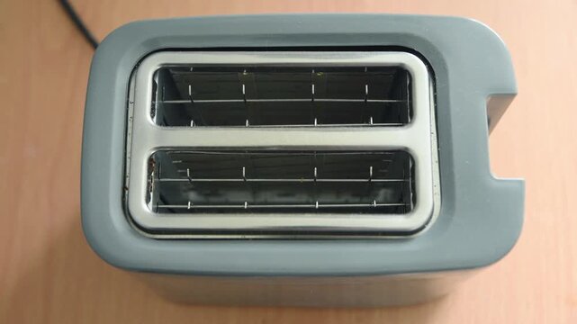 Top view toaster heating elements glowing red on wooden surface in sequence