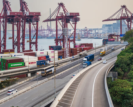 Hong Kong, China, 8 March 2026: elevated highways running beside container cranes and shipping containers at Kwai Chung container terminal with maritime infrastructure in the background.