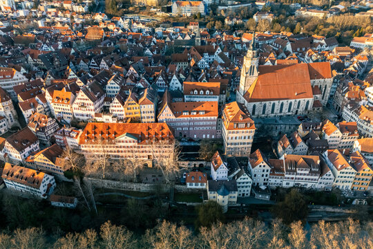 Aerial view of the historic Stiftskirche and traditional half-timbered houses in the old town during golden hour in Tubingen, Baden-Wurttemberg, Germany.