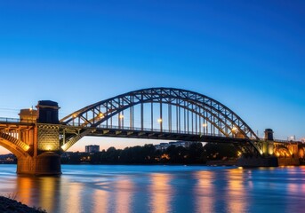 Naklejka premium Historic stone and steel arched structures crossing a wide waterway, lit up vividly at twilight, symbolizing industrial heritage and power, massive, ironwork, riveted