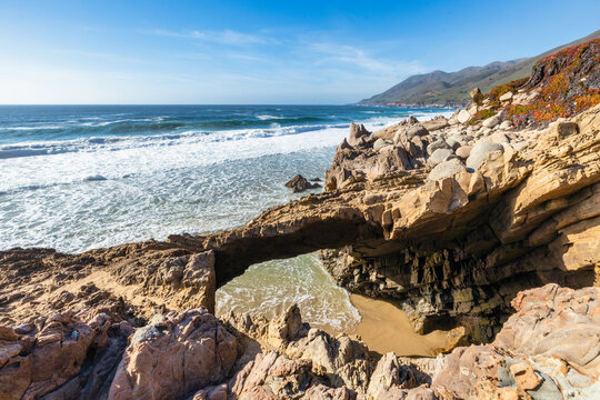 Natural rock arch and rugged coastal formations at Garrapata State Park along Highway 1, Big Sur, California, with Pacific Ocean waves and scenic coastline