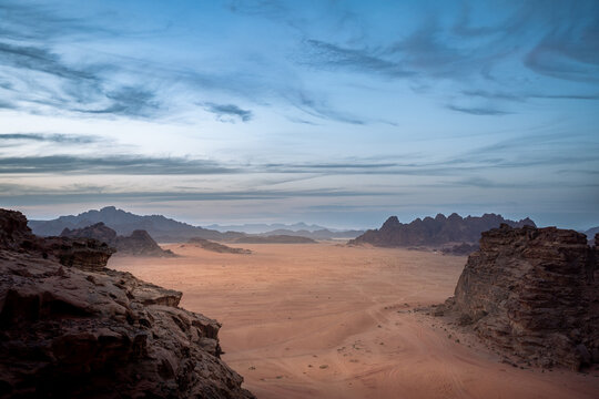 Panorama der W&uuml;ste Wadi Rum in Jordanien bei Sonnenuntergang, mit den markanten Felsen und viel Sand