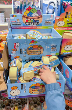 Child's hand reaching for a Rainbow Mystery dumpling squishy toy in a retail store display,Genk, Belgium, May 6, 2026