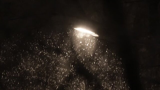 Snowfall against the background of light from a street lamp at night