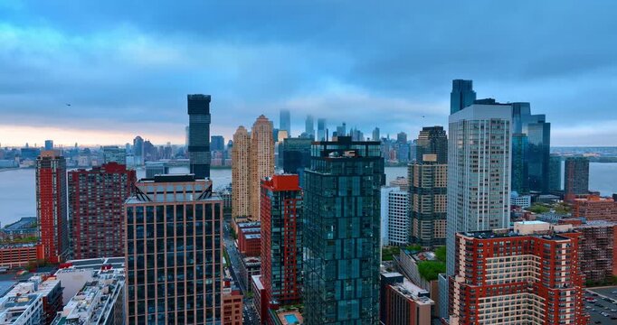 Footage at the tops of skyscrapers at the river waterfront of Jersey City, USA. Dramatic cloudscape is over the river and Manhattan skyline.