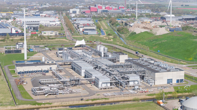 Aerial view of the Boekelermeer industrial facility featuring complex piping systems and large storage tanks under a clear sky in Alkmaar, Noord-Holland, Netherlands.