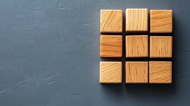 Nine light wood rectangular blocks arranged on a textured dark gray surface minimalist composition