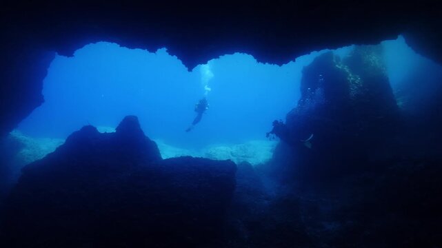 cave diving underwater scuba divers exploring caves and having fun ocean scenery sun beams and rays background
