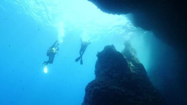 t the end of dive scuba divers coming back up to the surface to get on the boat underwater