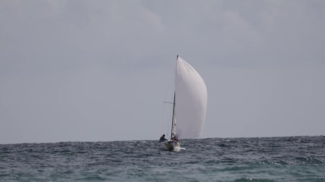 A small sailboat is sailing on the sea