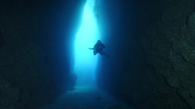 cave diving underwater scuba divers exploring caves and having fun ocean scenery sun beams and rays background