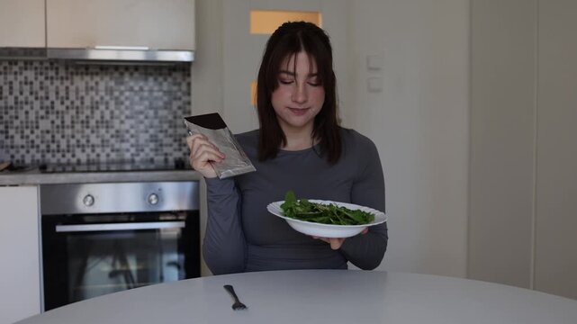Young woman searches for dopamine and emotional comfort from sweet chocolate realizing healthy salad cannot satisfy her cravings or improve mood