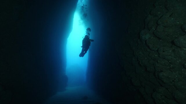 cave diving underwater scuba divers exploring caves and having fun ocean scenery sun beams and rays background