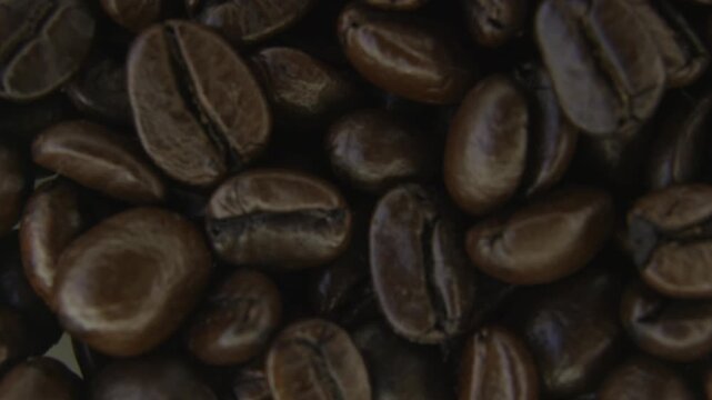 Macro Rotating Coffee Beans With Soft Smoke.