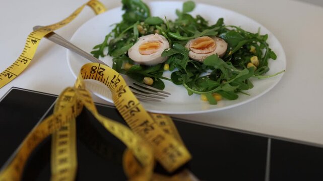 Fresh salad with eggs beside scale and measuring tape shows diet culture weight loss pressure calorie control and the struggle to eat well without obsession in daily life