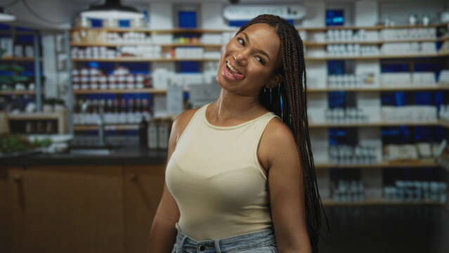 Woman showing cleavage smiling in pharmacy shelving with products and counter in view; warmth wellness.