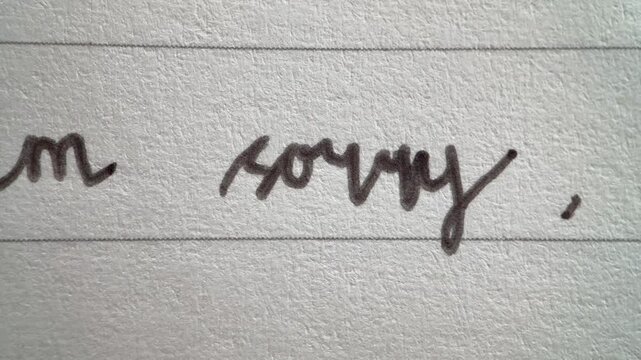 Macro video of the Ho'oponopono affirmation prayer handwritten on lined paper in cursive ink.
