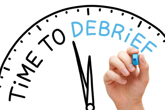 Hand Writing Time To Debrief Clock Concept