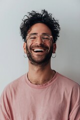 Fototapeta premium Young man laughing with eyes closed in studio setting