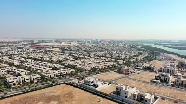 Aerial view of the modern Yas Acres residential community on Yas Island, Abu Dhabi, UAE, featuring luxury villas, contemporary architecture, and lush suburban development near the mangroves.

