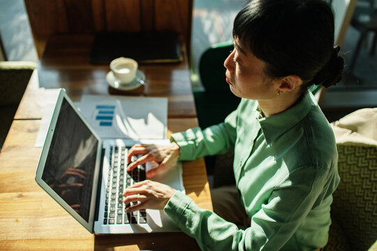 Businesswoman typing on laptop at coffee shop