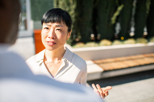 Professional woman talking with coworker outdoors