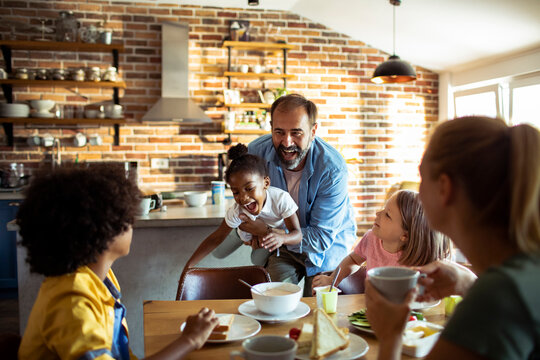 Happy family having fun at breakfast in cozy home kitchen