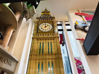 Naklejka premium Detailed Big Ben clock tower replica display inside a LEGO store in London, UK with ornate golden architecture and towering interior perspective