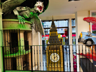 Naklejka premium LEGO Big Ben model and dragon display inside a colourful toy store in London, UK with clock tower replica and playful street view