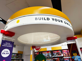 Fototapeta premium Build your own minifigures display at a LEGO store in London, UK with colorful bricks, signage and retail canopy showcasing toys, shopping and creative play in a modern family friendly interior