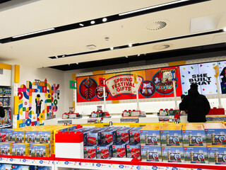 Fototapeta premium Busy LEGO store in London UK with shoppers browsing spring festival gifts and boxed sets on colorful shelves