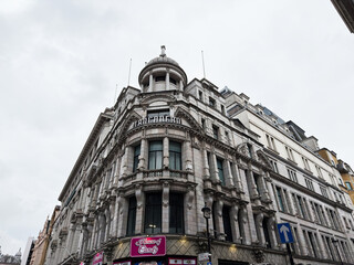 Naklejka premium Historic ornate commercial Trocadero building facade in London UK with classical architecture and domed corner tower above a House of Candy storefront